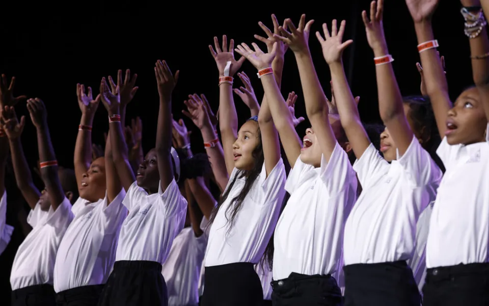 Students raising their arms during a music performance
