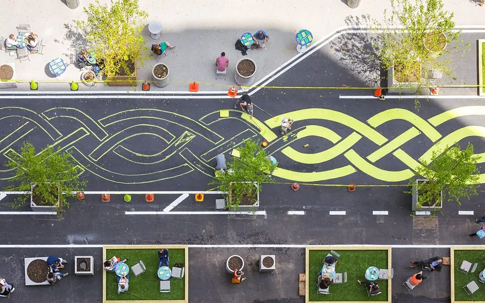 Aerial view of a street turned into public space with planters and seating