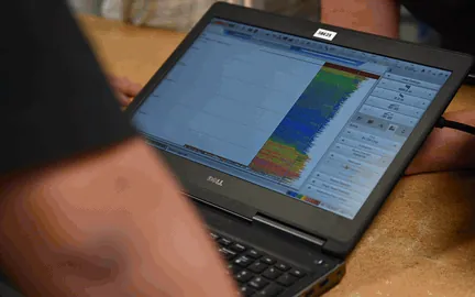 A laptop aboard a research vessel showing a sonar echogram